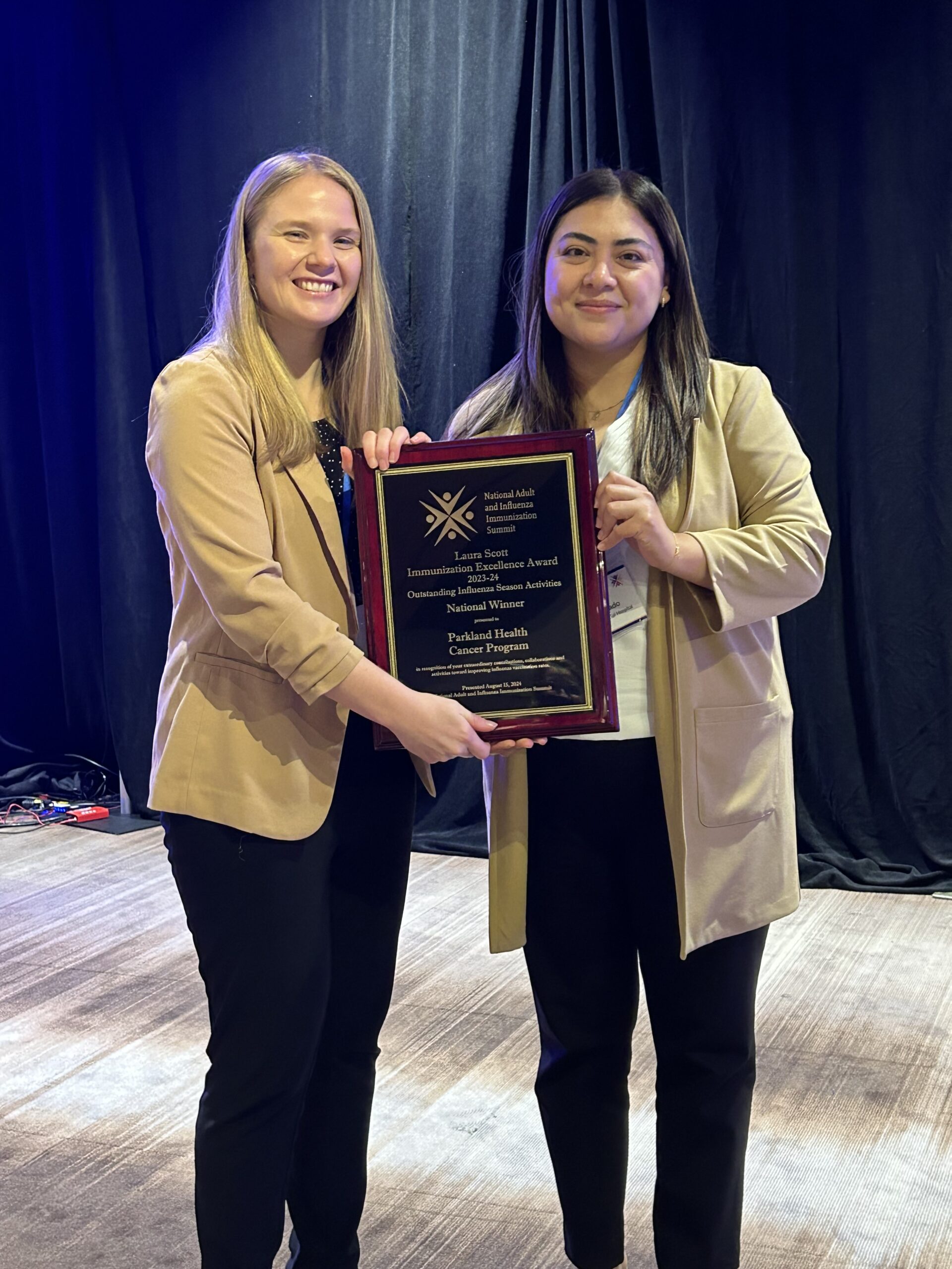 Andrea Semlow, MS, and Iza Delgado, RN accept flu vaccination award on behalf of Parkland Health's Cancer Program